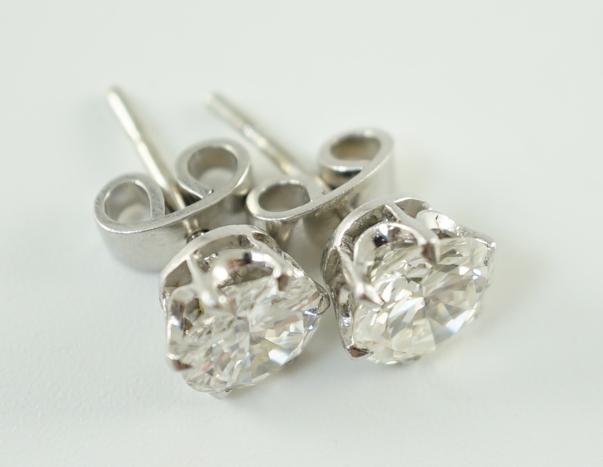 A pair of white gold and solitaire diamond set ear studs